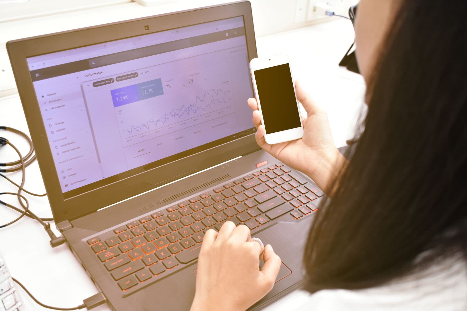 Webmaster revisa la analítica de su sitio con el teléfono en la mano